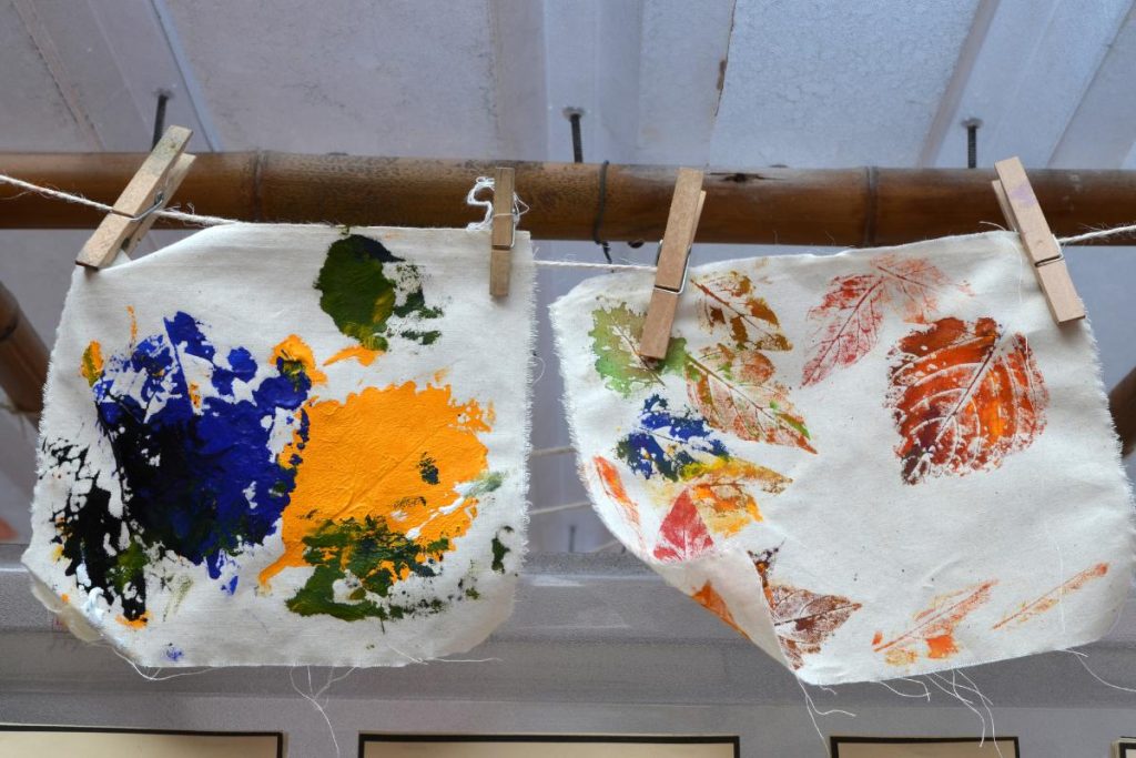 a leaf rubbing art work produced by a child onto fabric hanging up to dry.