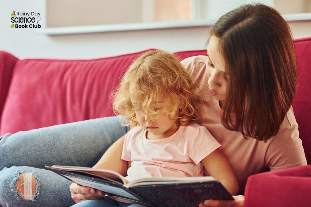 Mum and small daughter on the sofa reading a picture book together.